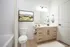 Elegant modern bathroom featuring a sleek vanity, framed art, and tasteful decor creating a refreshing ambiance.