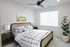 Bright, modern bedroom with elegant decor, featuring a cozy bed, stylish nightstand lamps, and a leafy plant under soft, natural light.