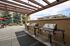 Inviting outdoor patio with modern stainless steel grills under a charming wooden pergola, surrounded by lush greenery and scenic views.