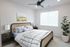 Elegant and cozy bedroom with a chic woven headboard, modern side tables, and calming natural light. Features minimalist decor with vibrant indoor plant.