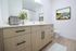 Modern bathroom featuring sleek wood cabinetry, elegant countertop, and stylish decor with a coastal painting.