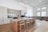 Bright and inviting open-concept kitchen featuring modern cabinetry, a sleek island with seating, and expansive windows for natural light.
