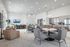 Spacious and inviting open-concept lounge with modern seating, a sleek kitchen area, and abundant natural light from large windows.