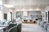 Elegant apartment interior showcasing a modern open-plan living and dining area with sleek kitchen design, stylish seating, and abundant natural light.