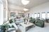 Spacious, modern living area with elegant sectional sofa, stylish armchairs, and open-concept dining space, perfect for entertaining.