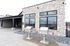 Charming outdoor patio area featuring twin stainless steel grills against a striking stone facade, with scenic mountain views reflecting in modern windows.