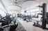 Spacious, state-of-the-art gym featuring modern cardio machines, ample free weights, and stylish design with abundant natural light.