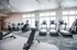 Bright and modern fitness center equipped with state-of-the-art treadmills and cycling machines, accented by sleek design and large windows for natural light.