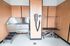 Modern pet grooming station with sleek stainless steel sink, convenient wall-mounted dryer, and adjustable grooming table in a stylish wood-paneled room.