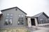 Modern single-story house featuring large windows, elegant stone accents, and a well-maintained landscape.