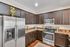 Contemporary kitchen with sleek stainless steel appliances, rich dark wood cabinets, and elegant marble countertops.