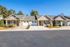 Charming duplex with inviting front porches, two-car garages, and manicured landscaping in a serene neighborhood.