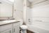 Modern bathroom featuring sleek fixtures, a spacious bathtub, and elegant cabinetry with ample storage.