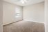 Bright and cozy carpeted bedroom with a ceiling fan and ample natural light from a window with blinds.