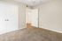 Cozy carpeted bedroom with ample closet space and modern white doors, perfect for a peaceful retreat.