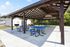 Inviting outdoor pavilion with blue picnic tables and grill area, perfect for gatherings and relaxation in a beautiful community setting.