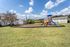 Inviting apartment complex with a vibrant playground, surrounded by lush greenery, perfect for families and outdoor enjoyment.