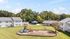 Inviting apartment complex with spacious outdoor area featuring a colorful playground, surrounded by lush greenery and well-maintained buildings.