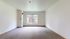 Bright and spacious empty room with large windows and neutral carpeting, perfect for creative interior designs and natural light.