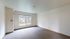 Bright and inviting empty room with a large window overlooking lush greenery, ideal for personalization.