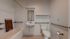 Accessible bathroom featuring a sleek design with a bathtub, safety grab bars, and modern fixtures.
