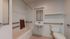 Modern, accessible bathroom with sleek grab bars, a practical sink, and contemporary fixtures.