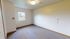 Bright and inviting room with neutral walls, large window offering scenic views, and plush carpet flooring perfect for a cozy ambiance.