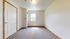 Bright and inviting empty room with a large window, offering ample natural light and a cozy carpeted floor, ideal for customization.