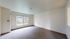 Bright and inviting living space with large windows, neutral tones, and lush outdoor views.