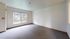 Bright, spacious room with large window offering a serene view of greenery, ideal for relaxation.