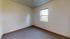 Bright and inviting empty room with a large window offering scenic views, perfect for customization and creativity.