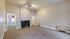 Elegant apartment living room with modern striped carpet, sleek fireplace, and ample natural light from adjoining rooms.