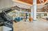 Modern apartment lobby with seating, stylish decor, and a prominent staircase to the mezzanine level to access more apartment amenities