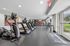 Modern fitness center with state-of-the-art treadmills, exercise bikes, and weight machines, featuring large windows for a bright workout environment.