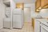 Bright and modern kitchen with sleek appliances, warm wooden cabinetry, and convenient in-unit laundry.