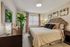 Elegant bedroom featuring a plush bed with a tufted headboard, stylish decor, and abundant natural light.