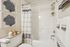 Elegant bathroom featuring modern white fixtures, stylish shower curtain, and decorative coral artwork for a serene ambiance.