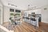 Kitchen with large white island and black bar stools and table and green chairs and white cabinets at AMLI RiNo apartments