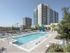 Exterior view of AMLI 3464 apartment community rooftop swimming pool with pool loungers and landscaping