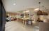 Resident lounge with large marble island at AMLI Old 4th Ward with various seating areas on tile floors and a kitchen.