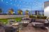 nighttime view of rooftop firepits with grey lounge seating and string lights at AMLI West Loop