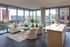 living room with a white sofa, two textured chairs, a kitchen island, dark flooring, and floor-to-ceiling windows with a city view at AMLI West Loop