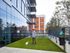 Daytime view of AMLI West Loop expansive dog run with a man and his small white dog standing on the artificial grass.