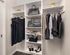 Spacious walk-in closet at AMLI West Loop with white built-in shelving and various clothing items hung up and on shelves.