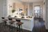 Kitchen at AMLI West Loop featuring light wood cabinetry, stainless steel appliances, a white counter peninsula with bar stools, and a small dining nook.