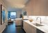 Kitchen with light wood cabinets and white tile backsplash with dark wood floors and view of  living space at AMLI West Loop