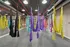 Interior view of an aerial yoga studio with hardwood flooring and floor to ceiling mirrors and a natural brick wall