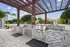 Exterior view of a grilling area at AMLI Dadeland apartments featuring steel top grills and two sinks with a wooden canopy