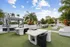 Exterior view of the rooftop amenity space at AMLI Dadeland with a swimming pool and several seating areas and palm trees