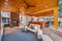 Shaded outdoor lounge area with ceiling fans, cushioned seating, brick fireplace, and bar at AMLI Frisco Crossing apartments